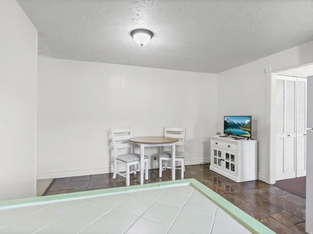 Recessed lighting, textured ceiling, tiled flooring, built-in storage cabinet, louvered bi-fold doors