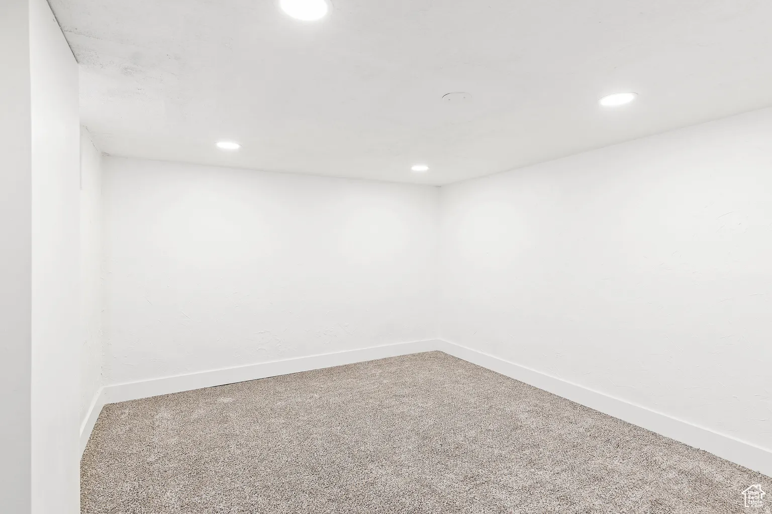 Recessed ceiling lighting, textured walls, and plush carpeting