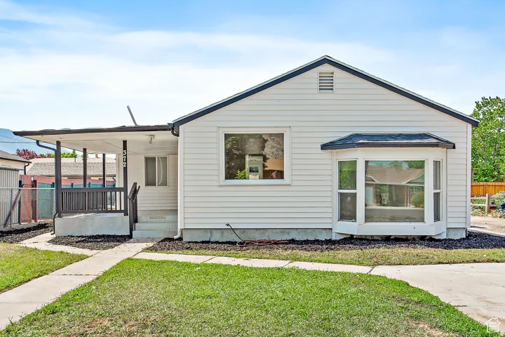 White exterior siding with a covered porch and dark railing