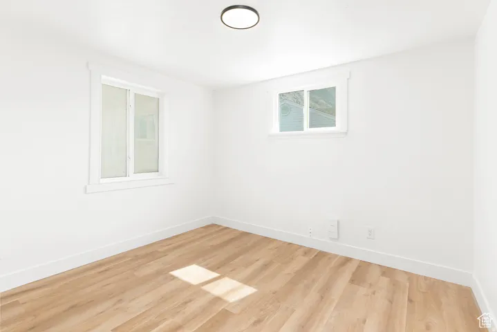 Recessed lighting, light wood-finish flooring, white walls, and white trim