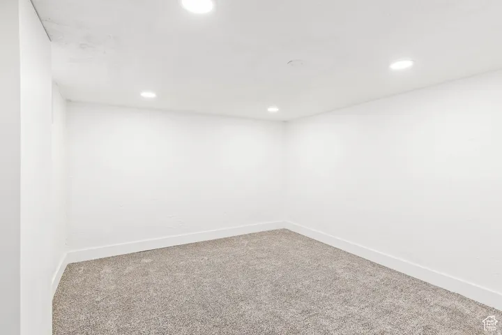 Recessed ceiling lighting, textured walls, and plush carpeting