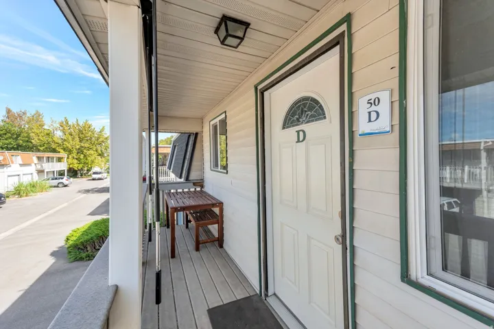 Front entry with white door, decorative glass arch, and external lighting fixture