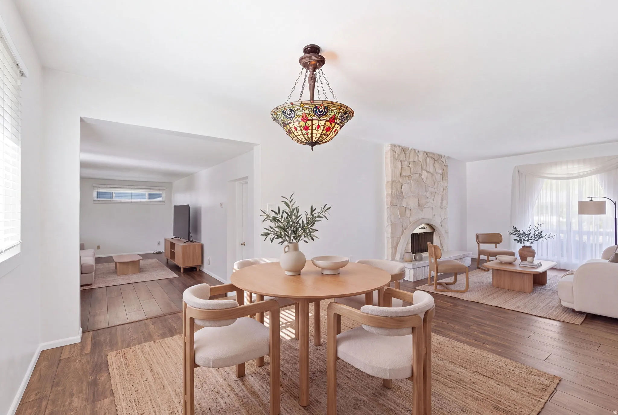 Wood-finish flooring throughout, with a decorative stone-clad fireplace and a distinct chandelier