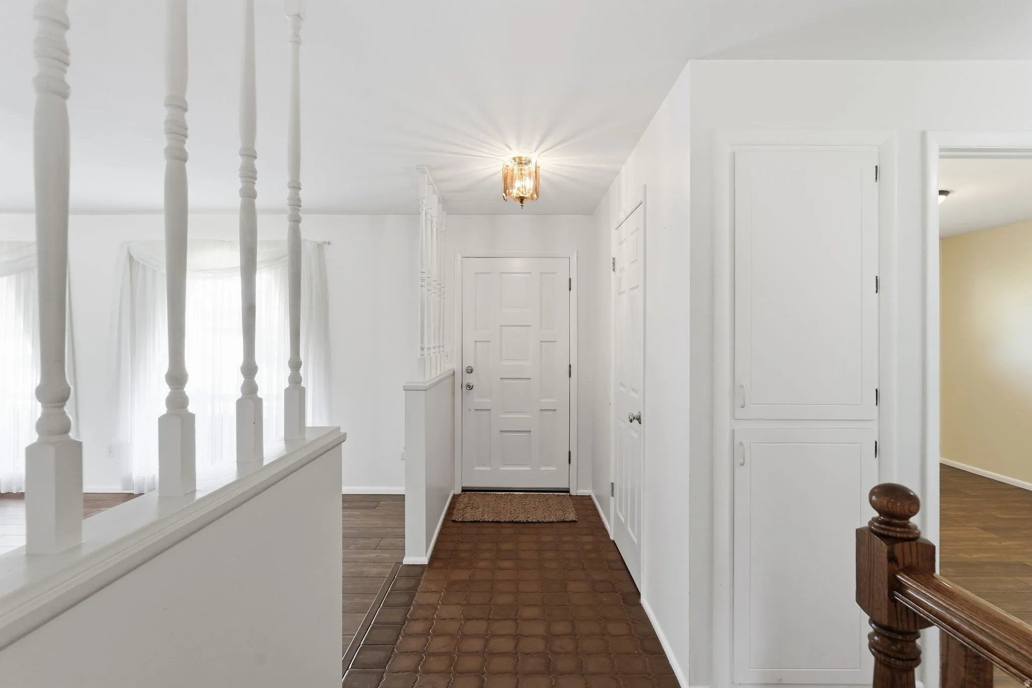 Entryway featuring a paneled door, ceiling-mounted fixture, and built-in storage cabinets