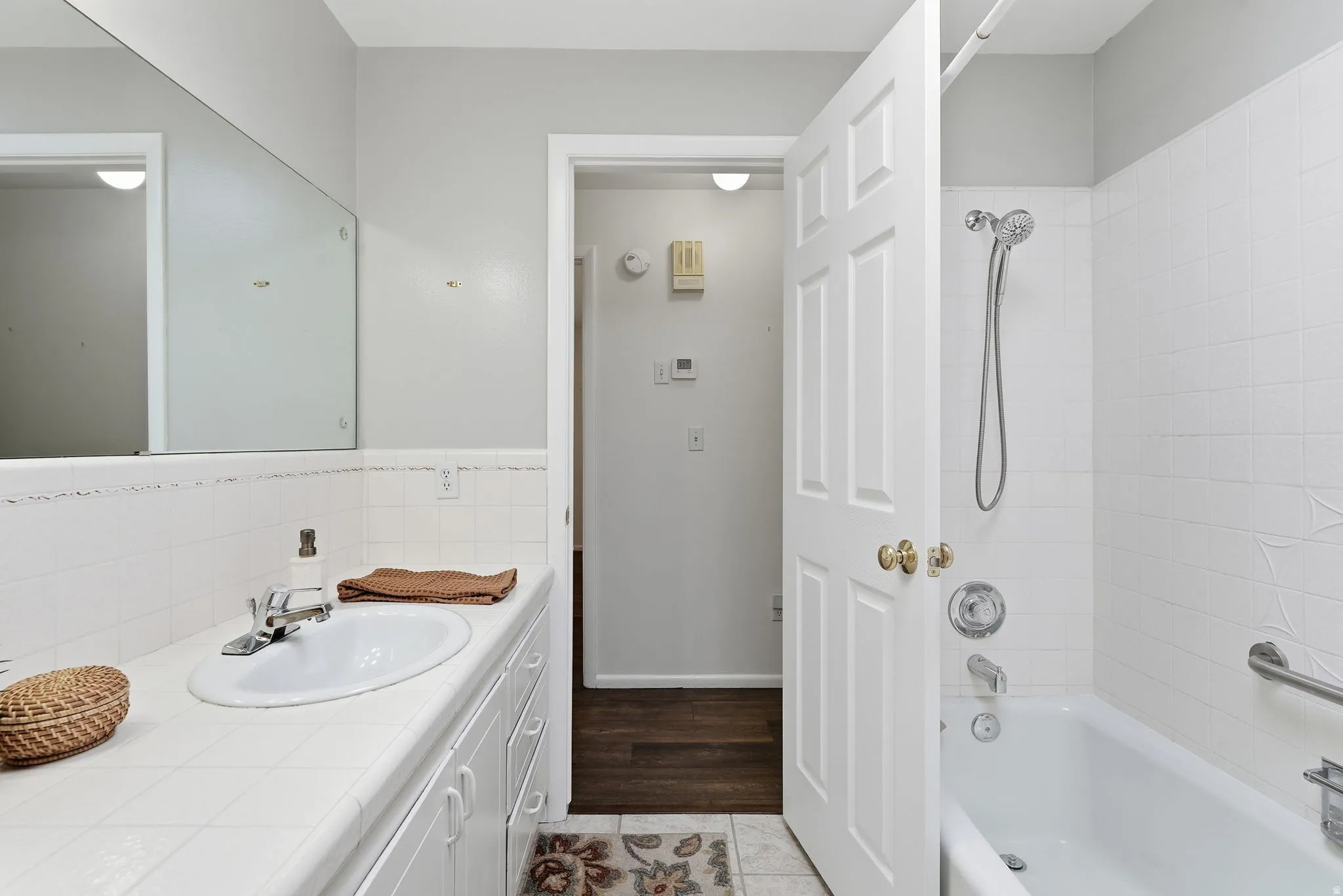 Vanity with an integrated sink, built-in cabinetry, and a full-width mirror