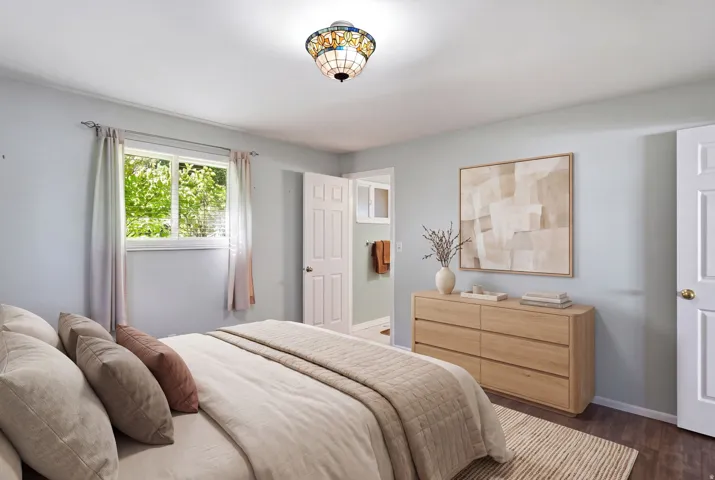 Recessed window with white trim, wood-finish flooring, and a decorative ceiling light fixture