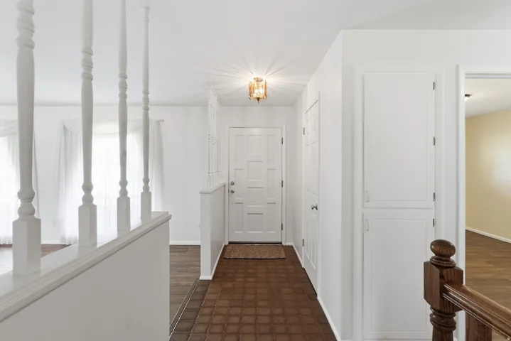 Entryway featuring a paneled door, ceiling-mounted fixture, and built-in storage cabinets