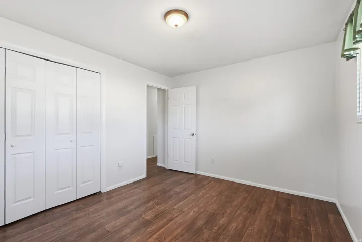 Wood-finish flooring, white walls, and a ceiling-mounted light fixture