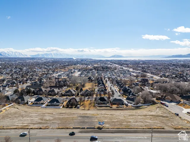 Expansive undeveloped land area with a surrounding residential community and distant mountain range backdrop