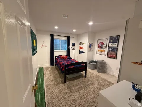 Recessed lighting, window with blinds and dark-toned drapes, light-toned wall paint, and light-toned carpet flooring