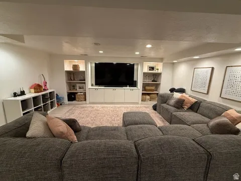 Recessed lighting, built-in media center with cabinetry, and integrated shelving units