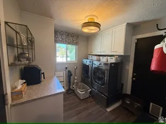 Laundry area featuring a window, built-in cabinetry, and wood-finish flooring