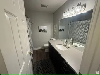 Single vanity with an integrated sink, polished chrome faucet, and a large mirror