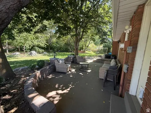Expansive outdoor patio with a concrete surface, bordered by a stone block retaining wall