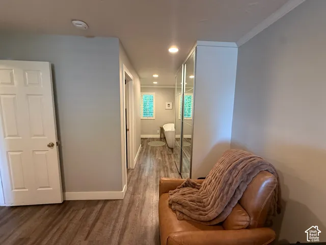 Wood-finish flooring throughout, bright white trim, recessed lighting, and built-in mirrored wardrobe