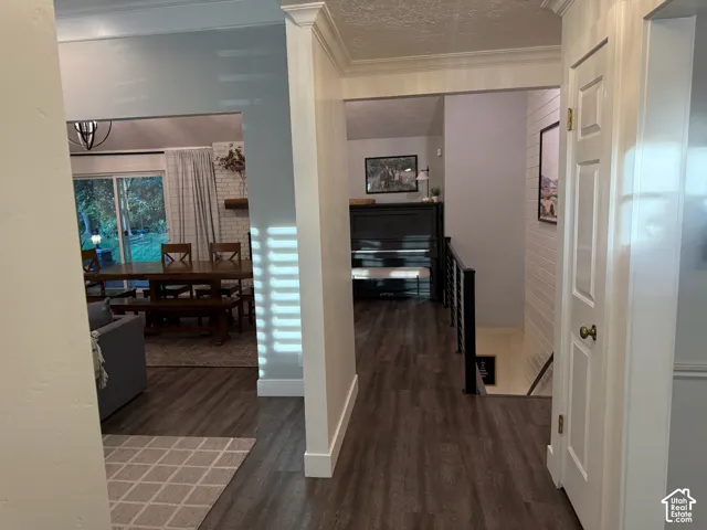 Wood-finish flooring, white trim, crown molding, and a sliding glass door