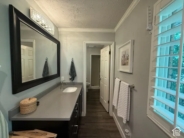 Long vanity with an integrated sink, quartz-finish countertop, and dark wood-finish cabinetry