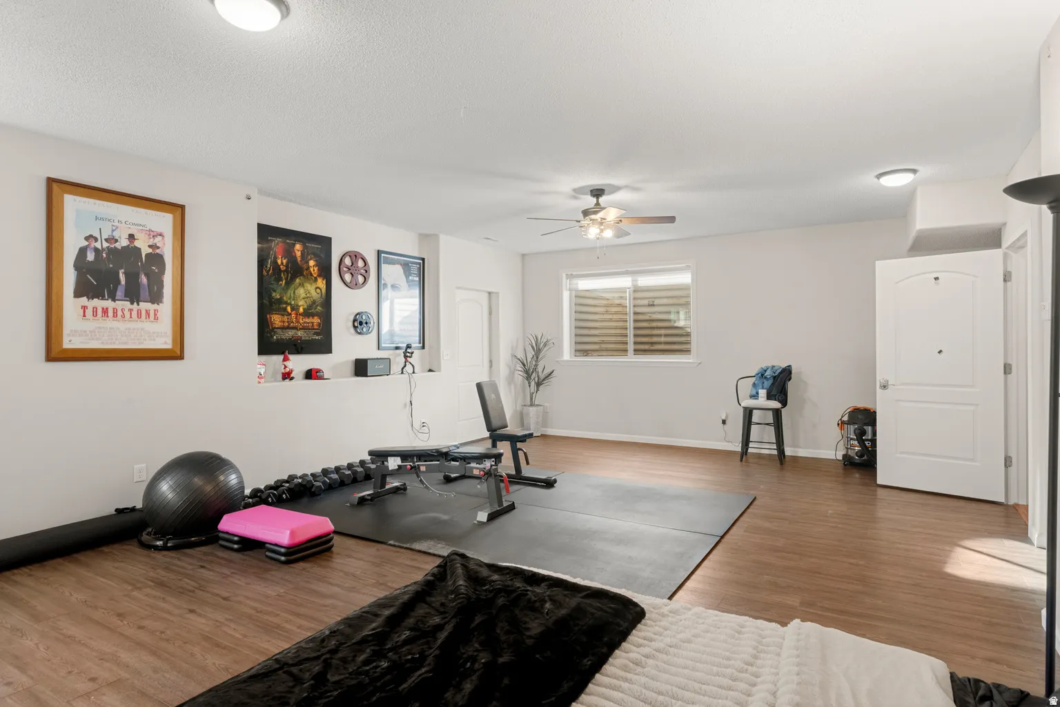 Wood-finish flooring throughout, recessed wall niche, contemporary ceiling fan, flush-mount ceiling lighting, and white interior doors