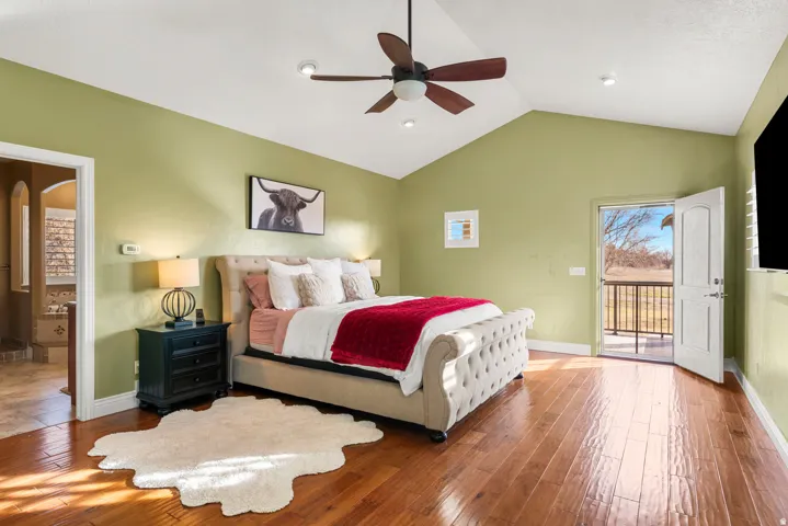 Vaulted ceiling with a ceiling fan, recessed lighting, wood-finish flooring, and direct access to an outdoor balcony