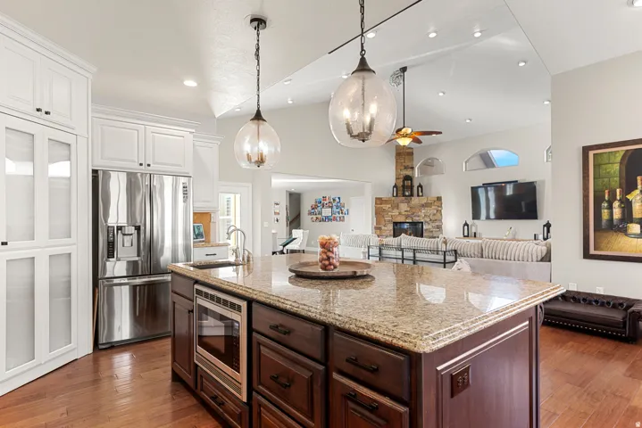 Kitchen island with a light-toned countertop, integrated microwave, and dark wood-finish cabinetry