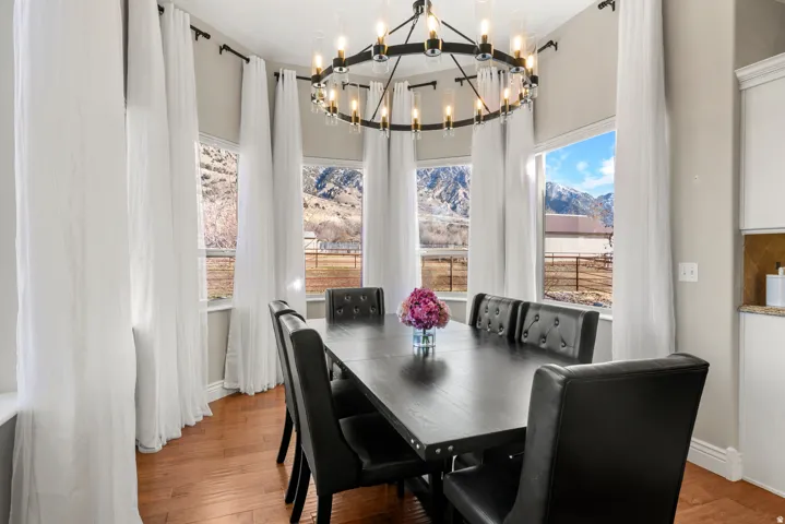 Dining space featuring a large bay window, wood-finish flooring, and a chandelier