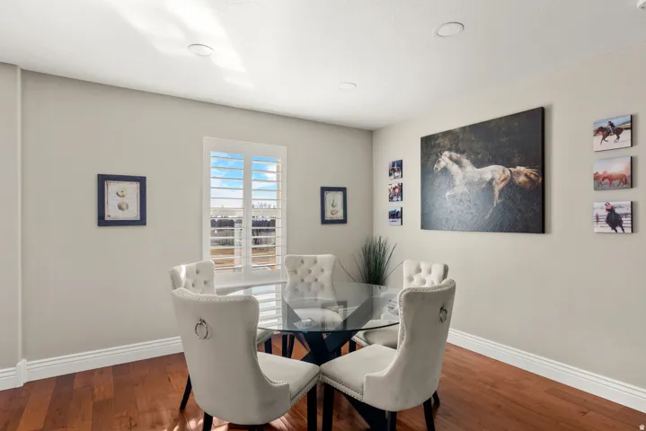 Hardwood flooring, recessed ceiling lighting, light-toned wall paint, and a window with plantation shutters