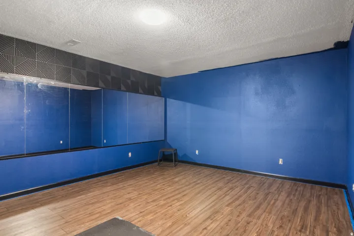 Wall-mounted mirror, wood-finish flooring, and recessed lighting