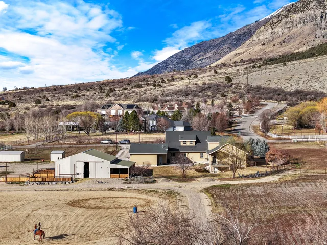 Mountain backdrop with a large main residence, separate barn structure, and expansive open land