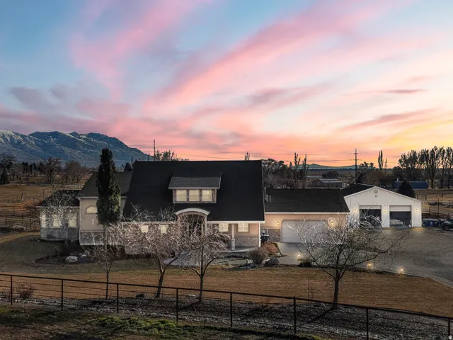 Expansive property featuring a multi-car garage, separate workshop structure, and a mountainous backdrop