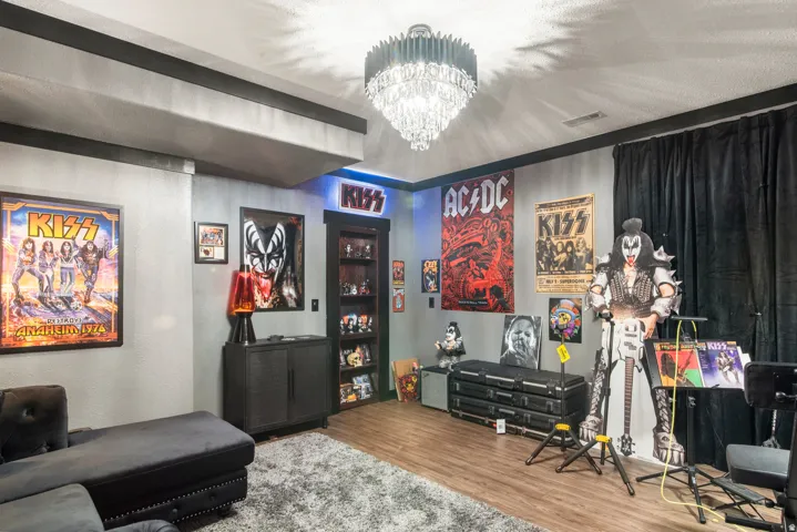 Recessed lighting, wood-finish flooring, built-in shelving, dark drapery, and a crystal chandelier