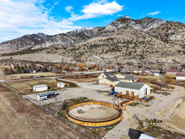 Expansive property featuring a circular fenced arena, two outbuildings, and a large multi-level deck