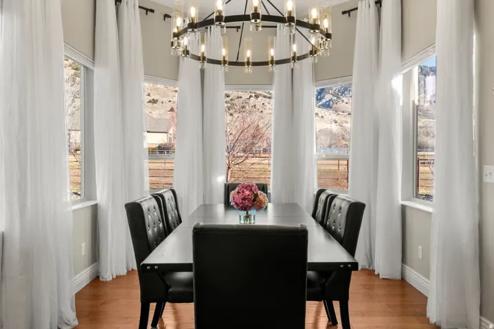 Bay window with multiple windows, hardwood flooring, and a chandelier
