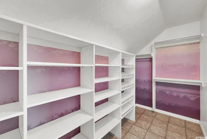Custom built-in shelving, sloped ceiling, and tiled flooring