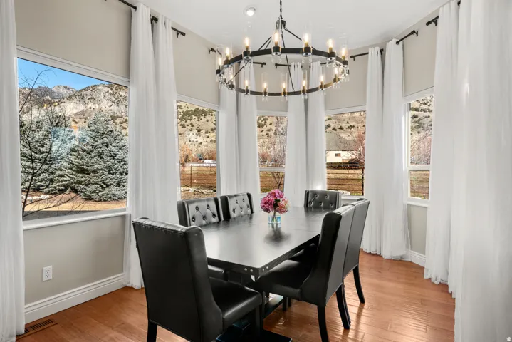 Elegant dining room bathed in natural light through multi-panel windows framing mountain vistas