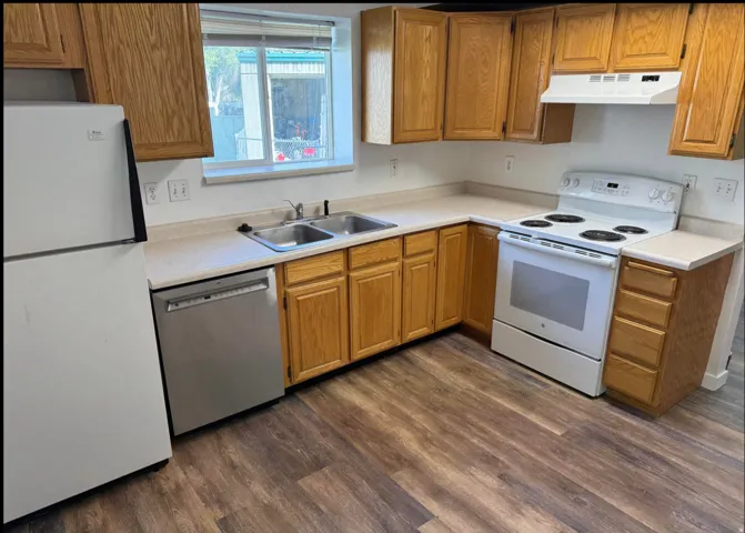 Kitchen featuring wood-finish flooring, light-toned countertops, and wood cabinetry