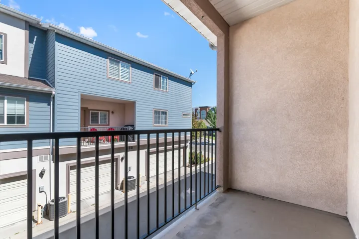 Private balcony with a concrete floor and black metal railing