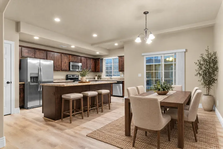 Kitchen with dark wood cabinetry, stainless steel appliances, and a central island with bar seating
