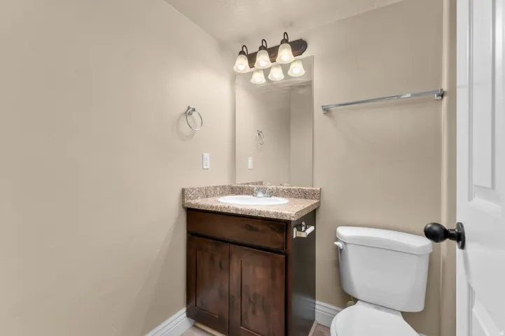Vanity with a wood-finish cabinet, a built-in sink, and a speckled countertop
