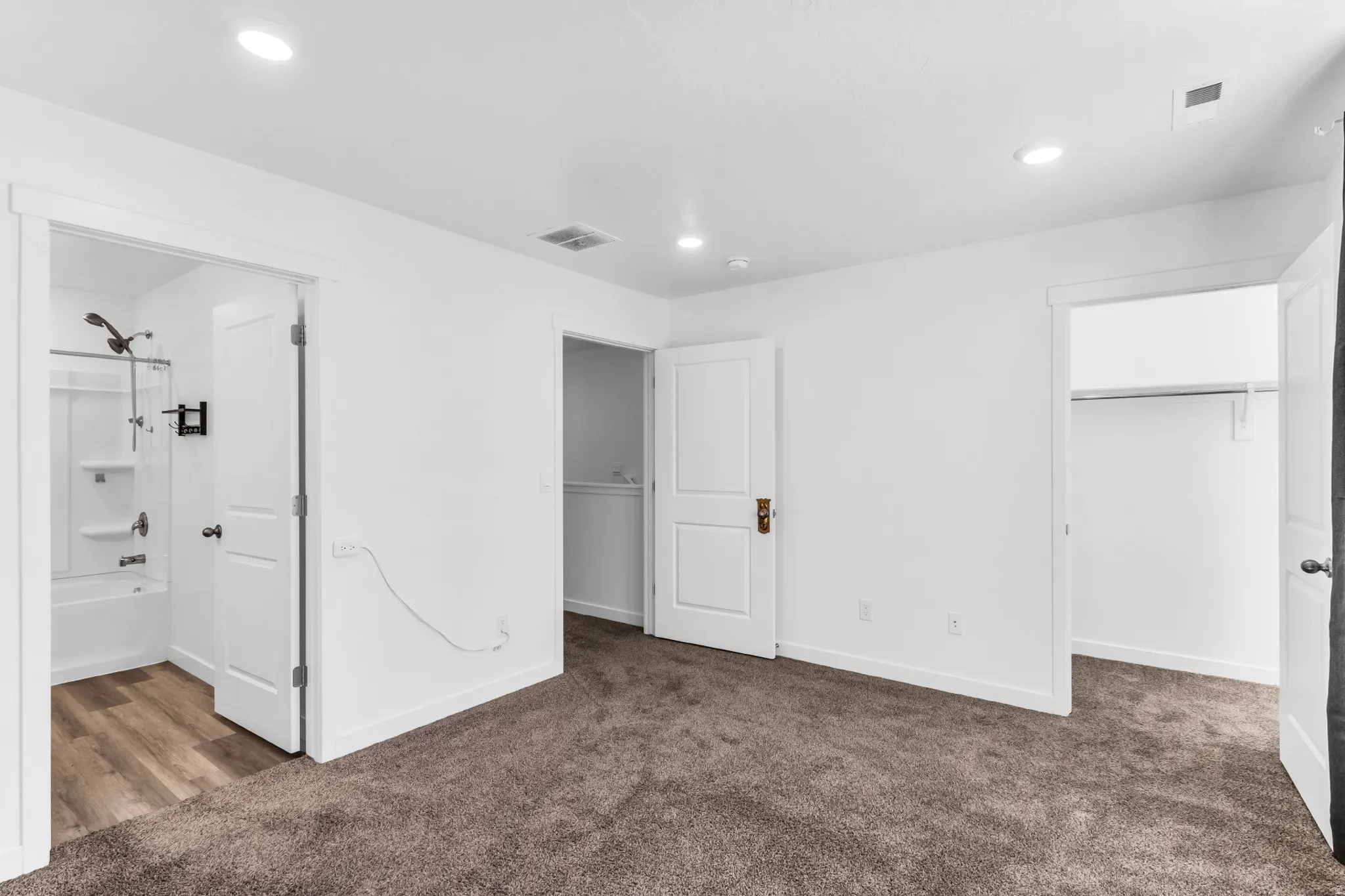 Wall-to-wall carpeting, recessed lighting, and a white interior paint scheme