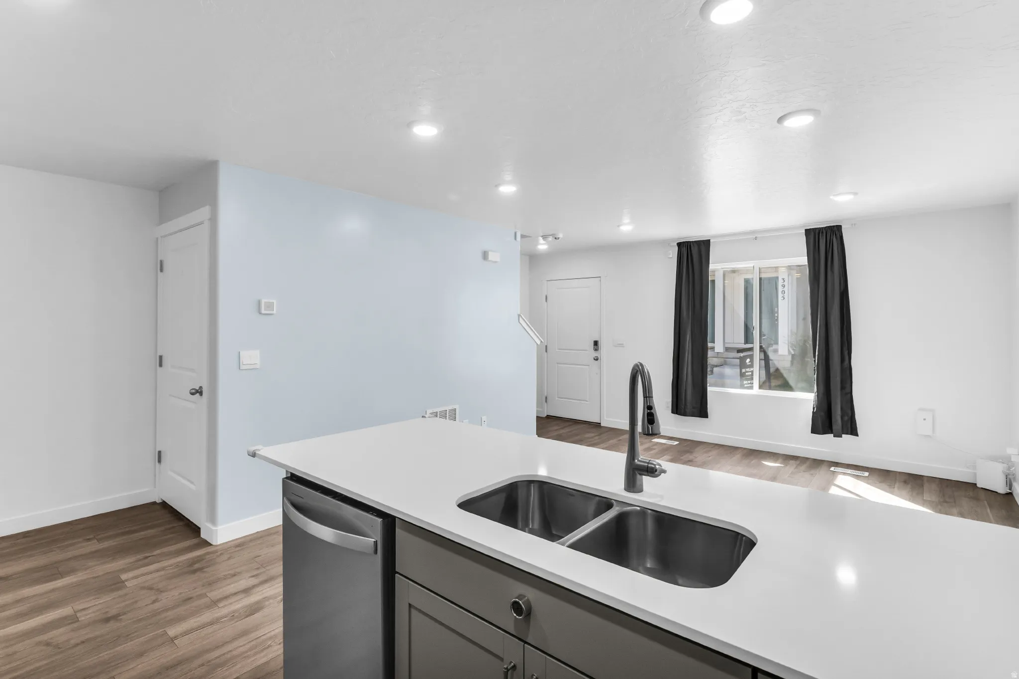 Kitchen island with an undermount dual-basin sink, stainless steel faucet, and integrated dishwasher