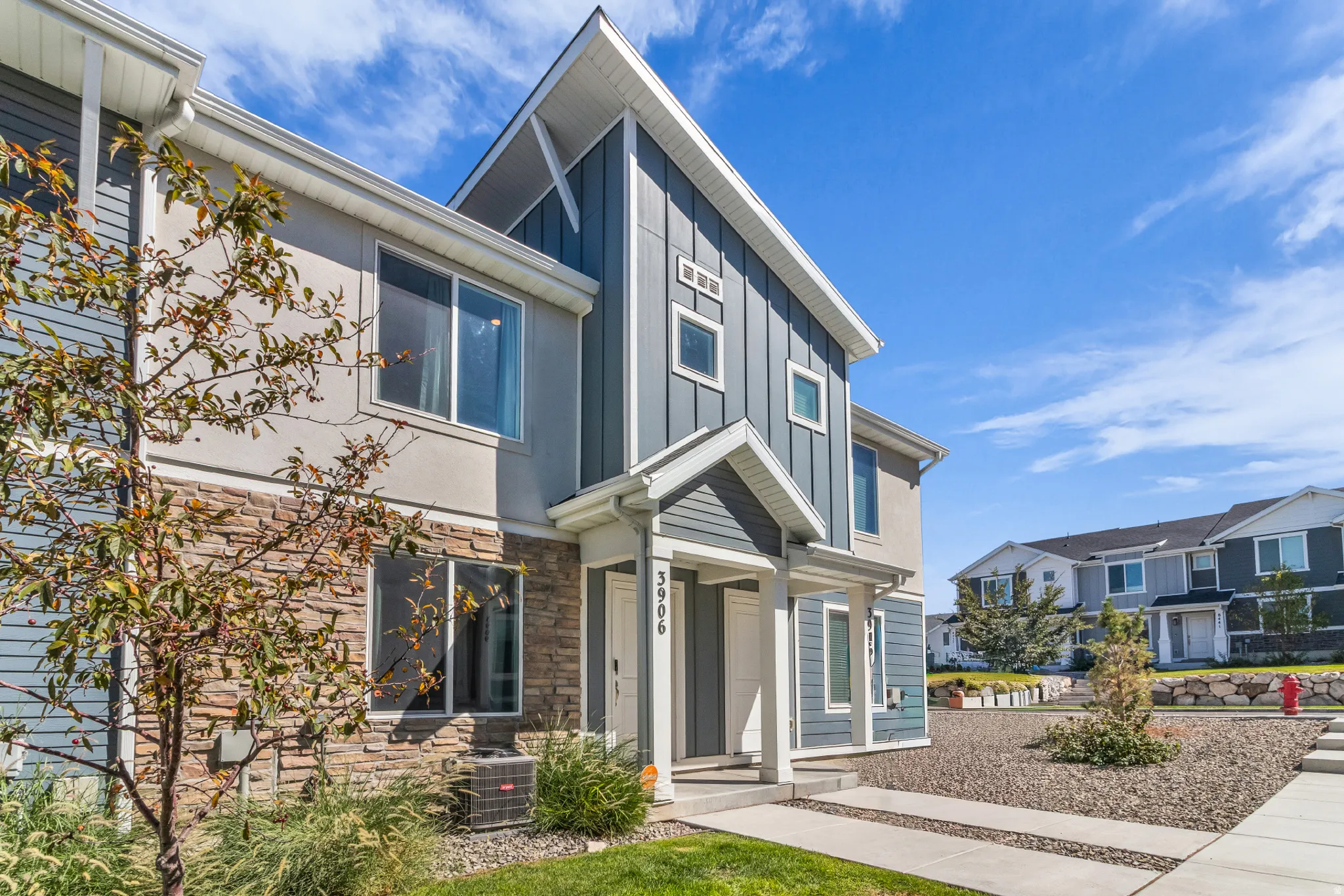Contemporary exterior featuring mixed material siding, stone accents, and a covered entry