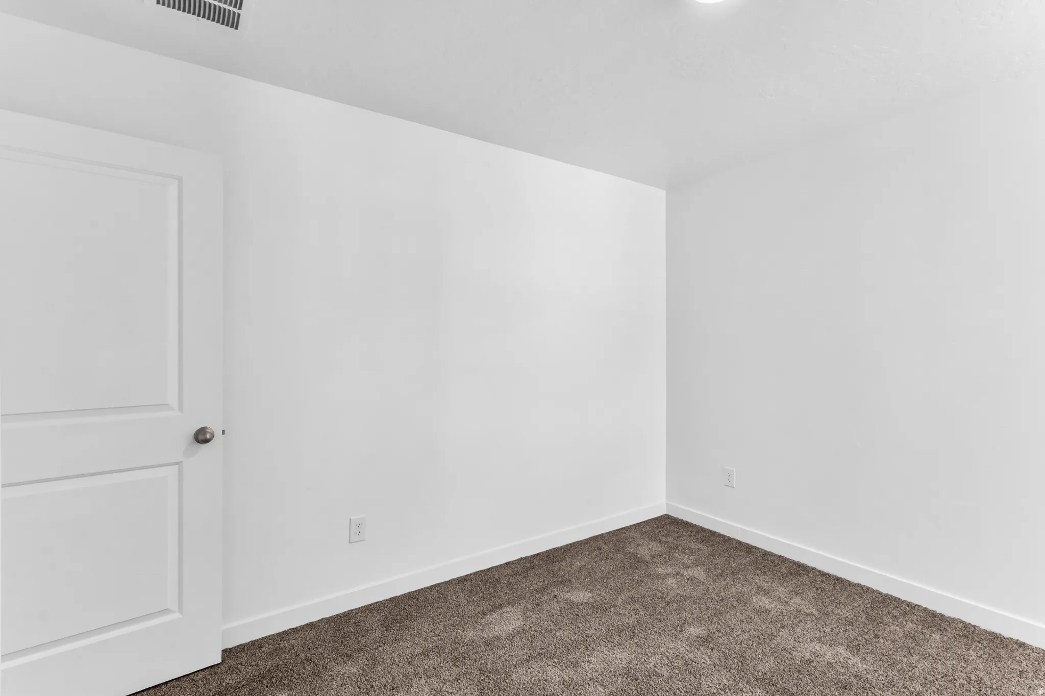 Neutral color palette, white walls, textured carpeting, recessed lighting, and white trim