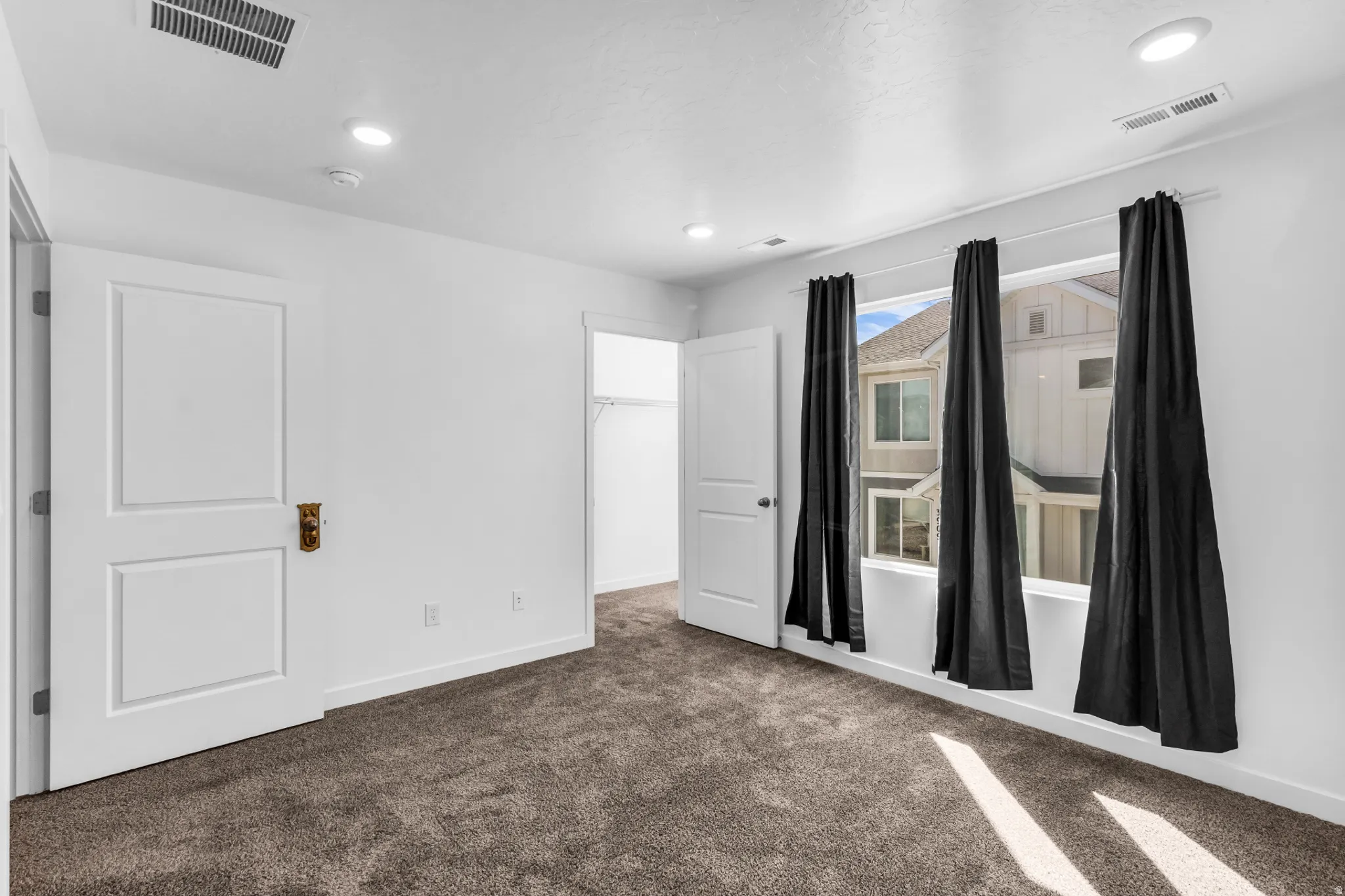 Plush carpet flooring, recessed ceiling lighting, two panel interior doors, and a built-in closet