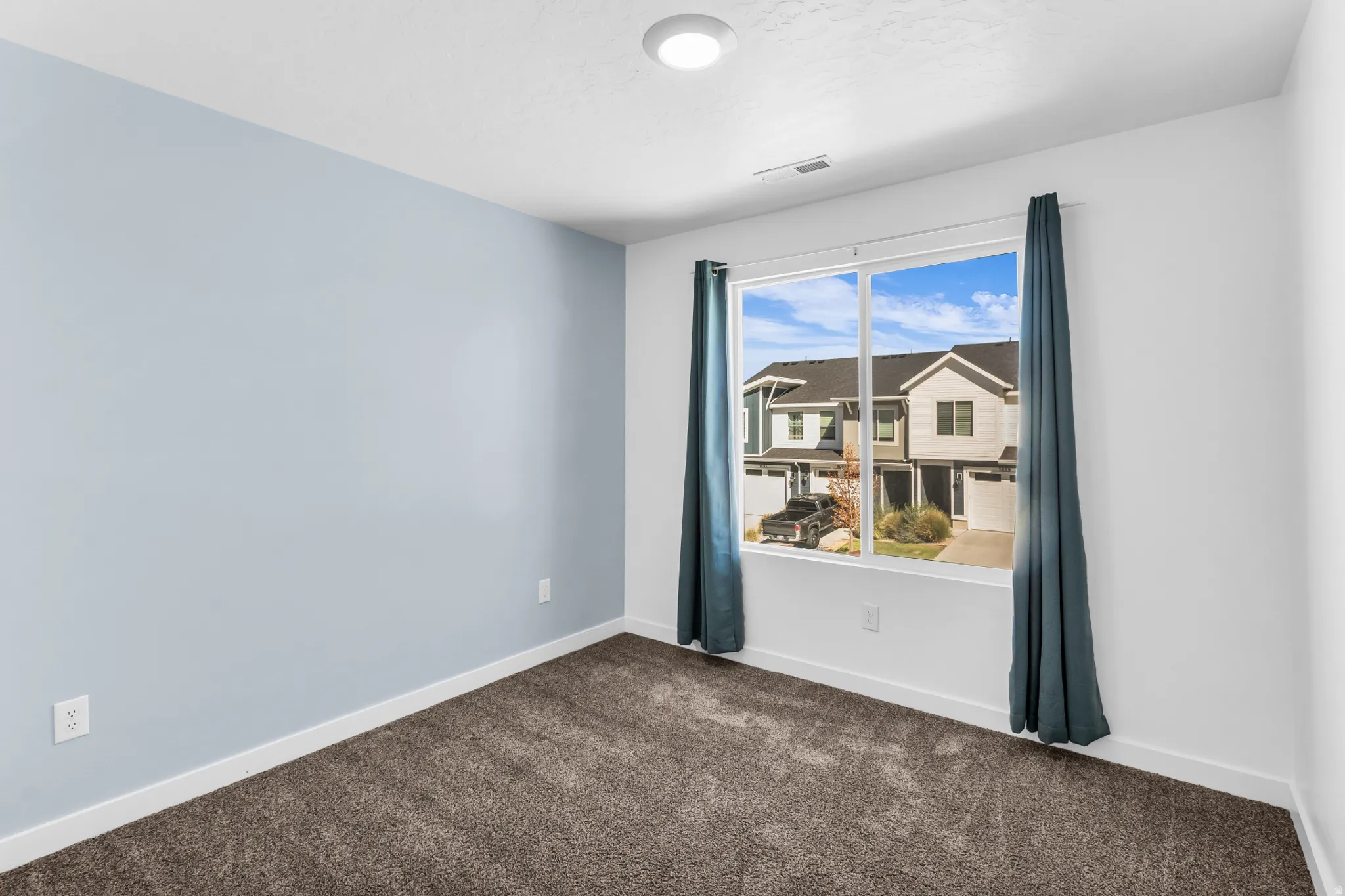 Window with surrounding white trim, carpeted flooring, and a recessed ceiling light
