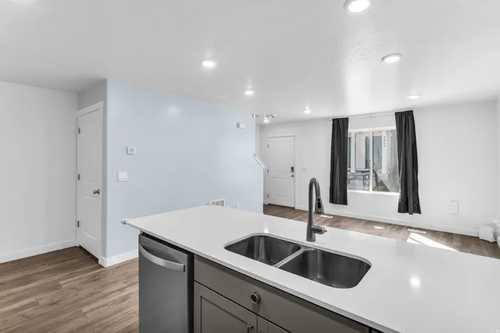 Kitchen island with an undermount dual-basin sink, stainless steel faucet, and integrated dishwasher