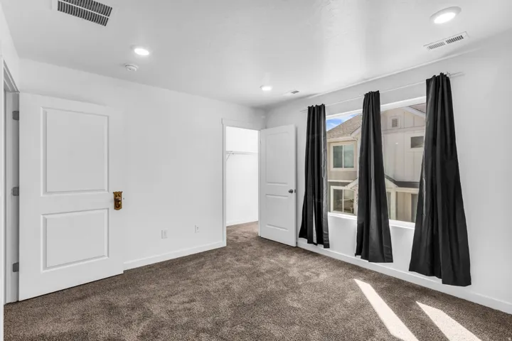 Plush carpet flooring, recessed ceiling lighting, two panel interior doors, and a built-in closet