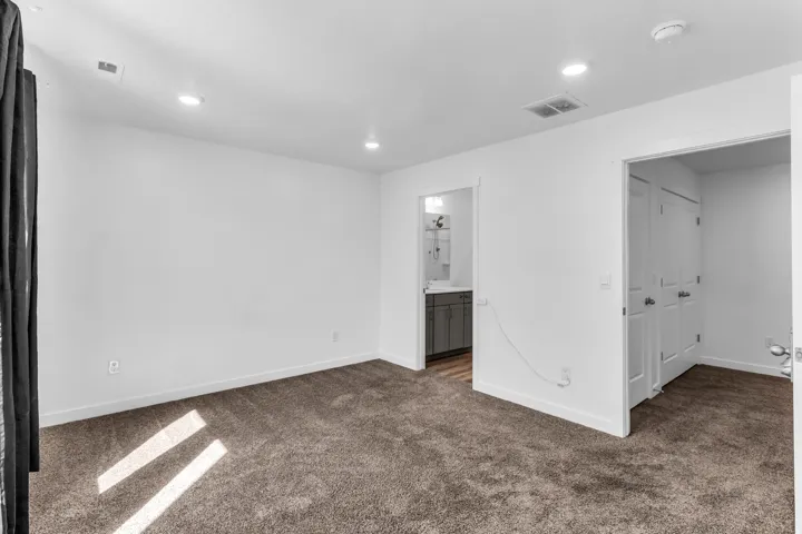 Recessed ceiling lighting, gray carpet flooring, white walls, and white trim