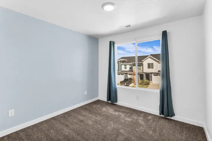 Window with surrounding white trim, carpeted flooring, and a recessed ceiling light