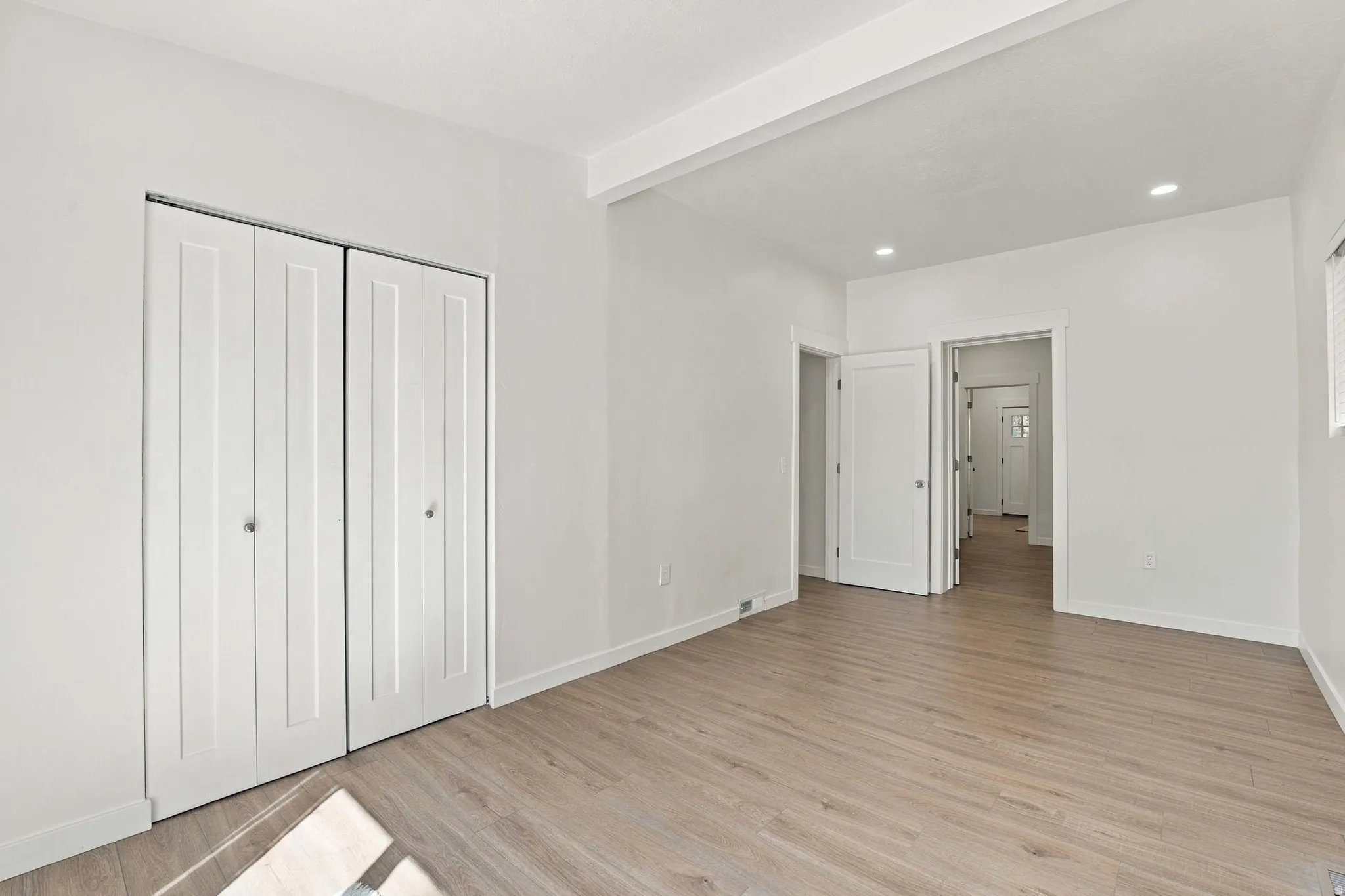 Light wood-finish flooring with white walls