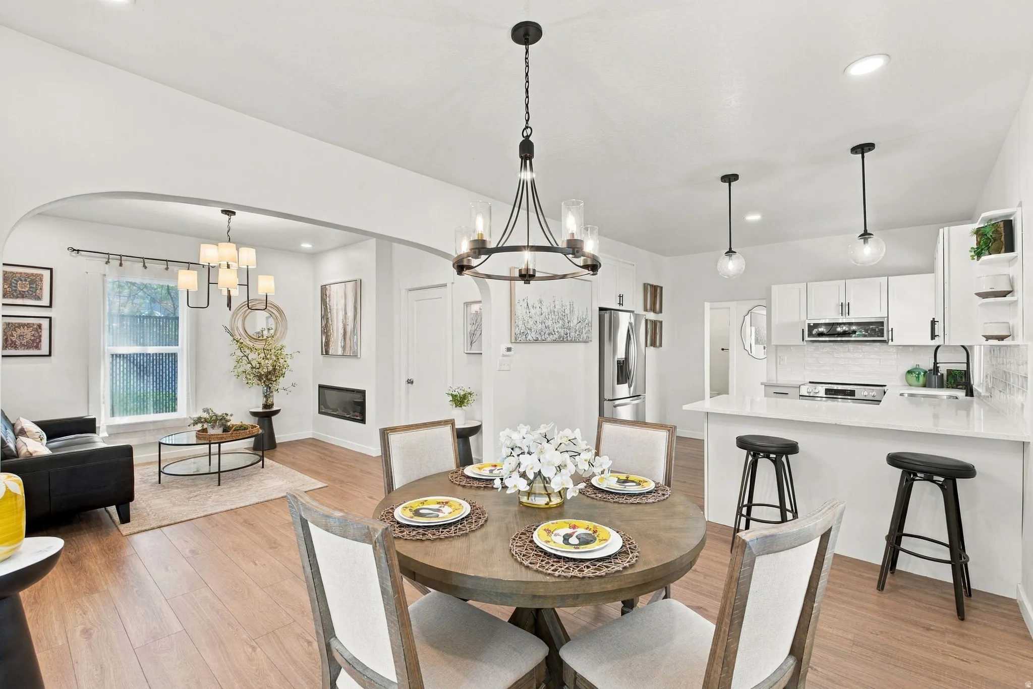Open concept living area with wood-finish flooring, a modern linear fireplace, and recessed lighting